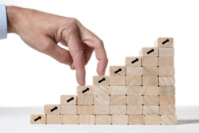 Close-up of hand holding toy against white background