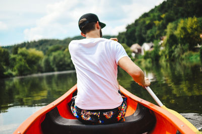Rear view of man on boat in lake