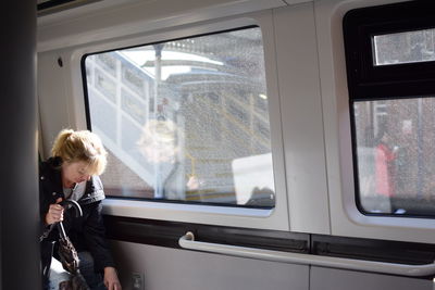 Rear view of boy looking through train window