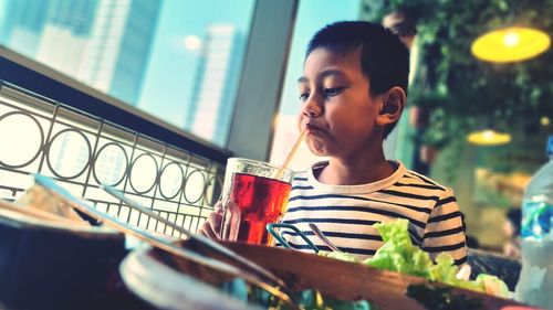 Boy drinking ice tea in cafe