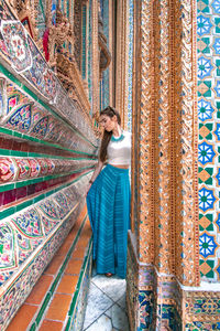 Beautiful woman standing in mosaic building