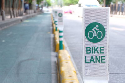 Close-up of bicycle lane sign by road