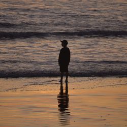 Rear view of silhouette boy on beach