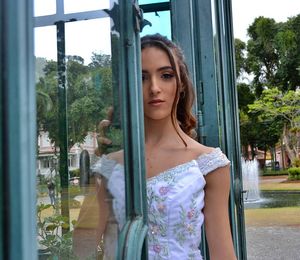 Portrait of woman standing by window