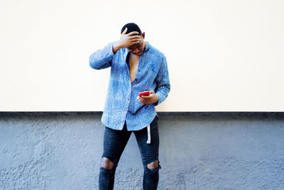 Young african man playing on his smartphone