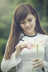 Close-up of woman holding red flowering plant