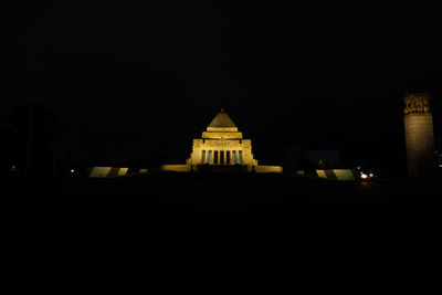 Illuminated building against clear sky at night