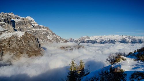 Scenic view of snowcapped mountains against blue sky