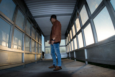 Full length of man standing on window