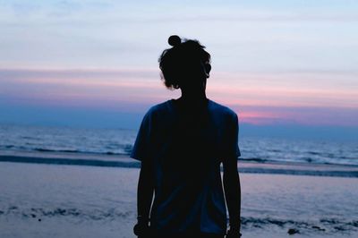 Rear view of man looking at sea against sky