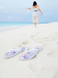 Rear view of woman on beach against sky