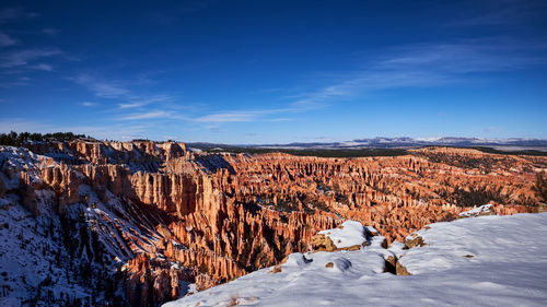 Scenic view of snowcapped mountains against blue sky