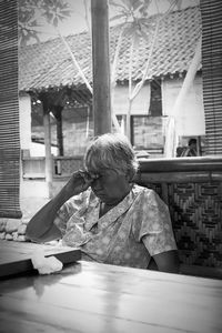 Mature woman rubbing eyes while sitting on restaurant