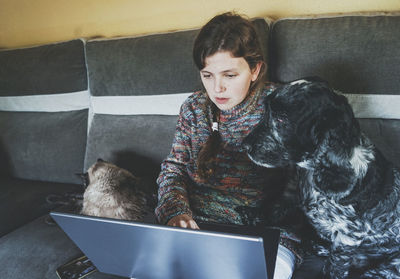 Woman working on laptop by pets at home