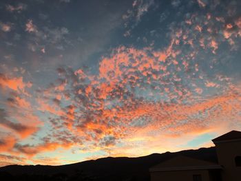 Scenic view of silhouette mountains against orange sky