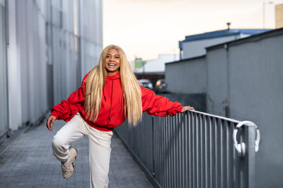 Cheerful african american woman with long blonde hair wearing sportswear and wearing headphones