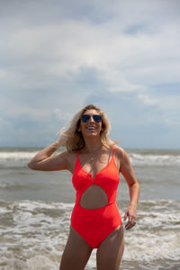 Young woman wearing sunglasses while standing on beach