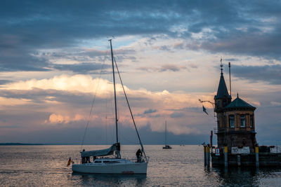 Sailboats sailing on sea against sky during sunset