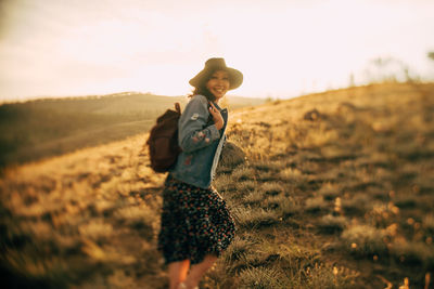 Portrait of smiling young woman standing on field