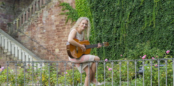 Full length of a smiling young woman playing outdoors