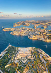 High angle view of city by sea against sky