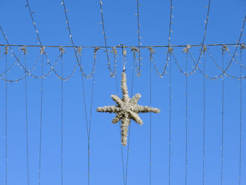 Low angle view of christmas decoration against blue sky