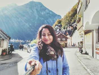 Portrait of young woman standing on road by hallstatter see lake