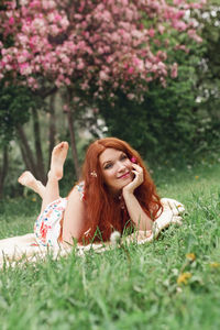 Portrait of woman sitting on grassy field