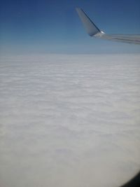 Cropped image of airplane flying over clouds