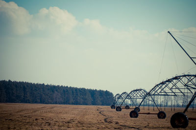 Wheeled objects on landscape against sky