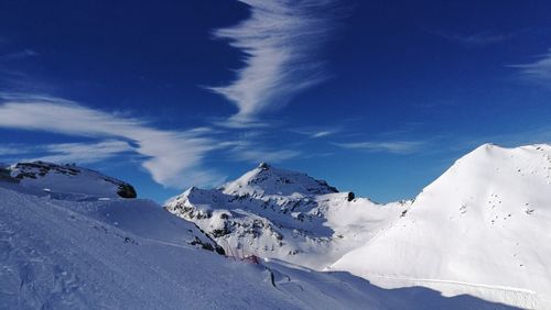 Scenic view of snowcapped mountains against blue sky