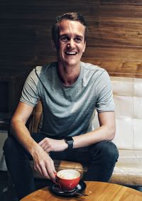 Portrait of a smiling young man sitting at table