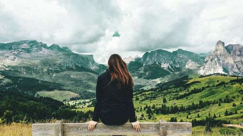 Rear view of woman looking at mountain against sky