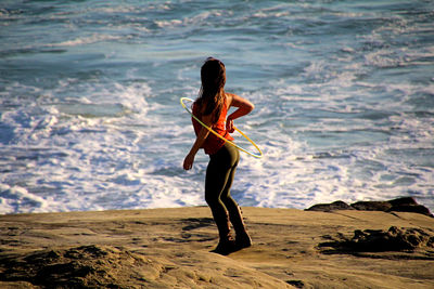 Full length of woman standing at sea shore