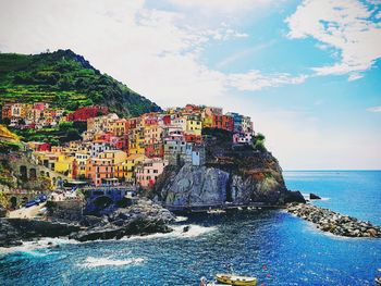 Scenic view of sea by buildings against sky