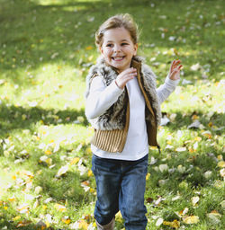 Smiling girl looking away while running on field