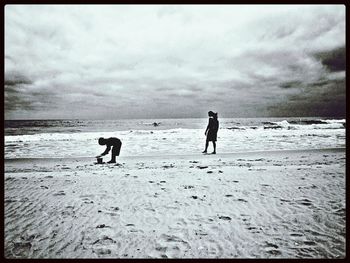 Scenic view of beach against cloudy sky