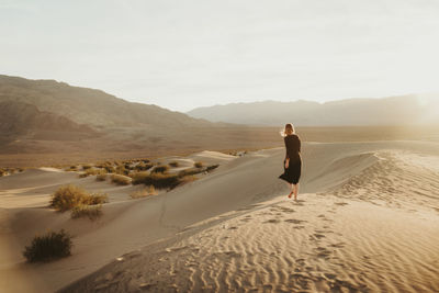 Rear view of man on beach against sky