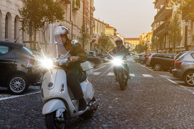 Sun shining over cars on street in city