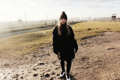 Portrait of young woman standing on sand