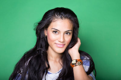 Portrait of smiling woman against green background