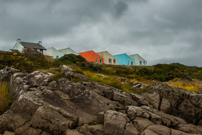 Buildings by mountain against sky