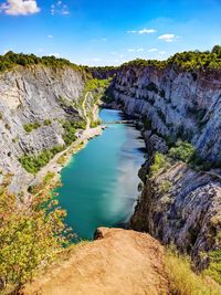 High angle view of river amidst cliff against sky