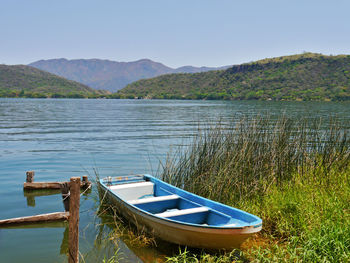 Boat moored in lake against clear sky