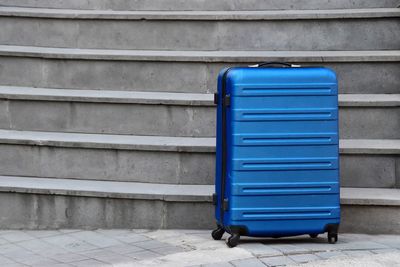 Blue luggage against steps in city