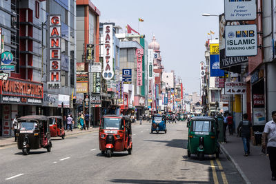 Rickshaw on street amidst buildings in city