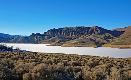 Scenic view of mountains against clear blue sky