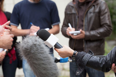 Cropped hand interviewing businessman with microphone