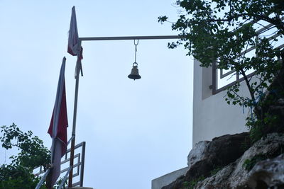 Low angle view of street light by building against sky