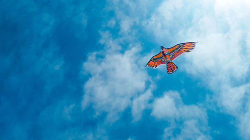 Low angle view of butterfly flying in sky